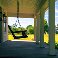 Empty porch swing on rural farm